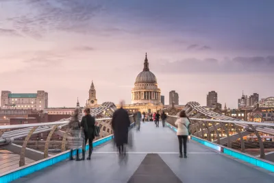 An image of pedestrians walking across the Millennium Bridge toward St. Paul's cathedral in London.