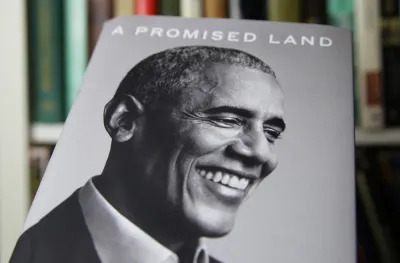 An image of the book "A Promised Land," by Barack Obama shows a black and white photo of the former president smiling.