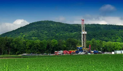 Marcellus shale gas-drilling site with tall white tower against green hills along PA Route 87, Lycoming County, Pennsylvania
