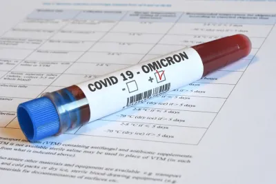 A vial of blood marked "Omicron" sits on top of paperwork indicating relevance to Covid-19.
