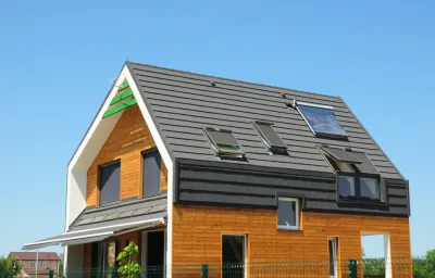 Modern Passive House Exterior. Modern energy efficiency house with skylight windows and solar panels on the roof top.