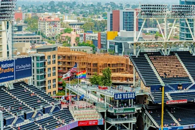 An image of stadium seats at Petco Park in San Diego, with new buildings under construction nearby in the background.