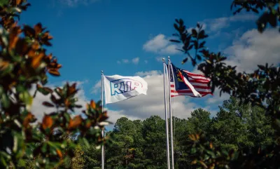 Flags on tall flagpoles with RTP logo and North Carolina flag at Research Triangle Park.