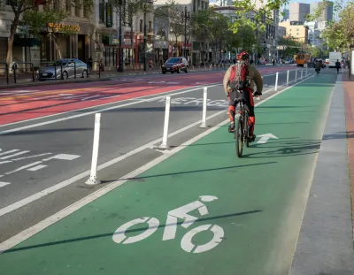 A cyclist commutes along a painted bike lan on Market Street in San Francisco.
