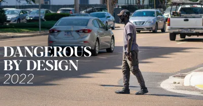 Pedestrian crossing street with cars in background and "Dangerous by Design 2022" white font