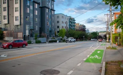 Green painted bike lane on street next to modern mid-rise apartment buildings in Seattle, Washington.