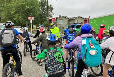Group of children with backpacks and bike helmets going to school.