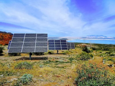 Solar panels installed ona hillside with Lake Mead, Nevada in background.
