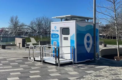 Blue and white Throne portable bathroom in an outdoor location.
