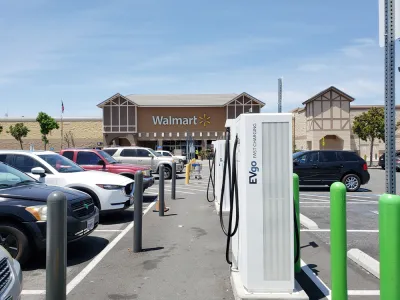 Electirc vehicle charing stations are visible in the parking lot of a Walmart store.