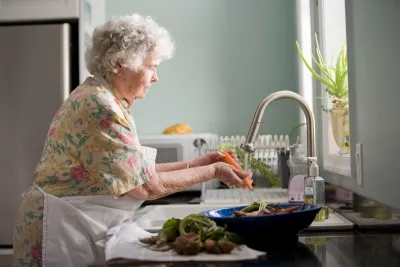 Senior Woman Washing Vegetables