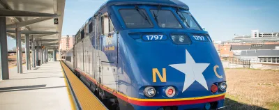 Blue train with white star and NC logo at platform in North Carolina.