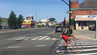 Person biking at intersection between Atlantic Avenue and Franklin Avenue in Brooklyn, New York City