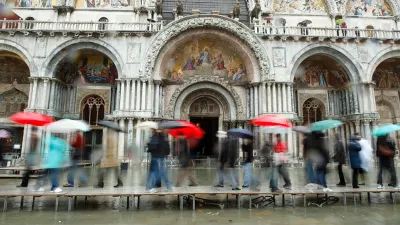 Tourists on walkways over flood waters in Venice