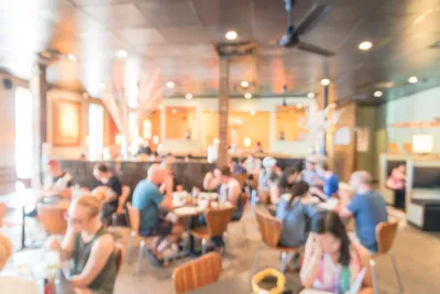 Blurred photo of crowded, brightly lit restaurant