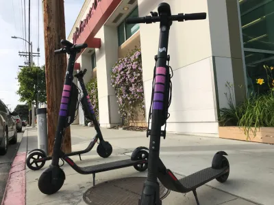 Three Lyft electric scooters parked on a sidewalk in West Los Angeles