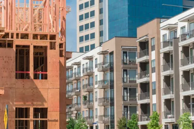 Apartment building under construction with other new apartment buildings and taller glass office towers in background in Dallas, Texas