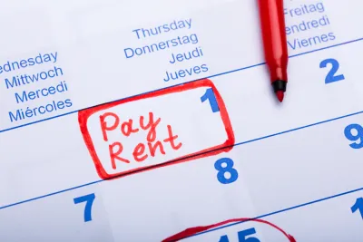 Close-up of calendar on day 1 of month with "Pay Rent" written in red marker