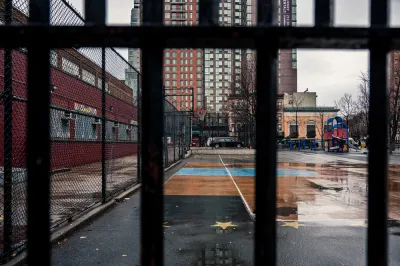 View of concrete schoolyard in New York City through fence