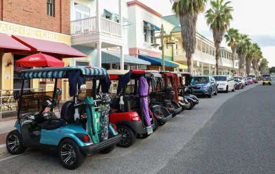 Line of colorful golf carts parked outside restaurant in The Villages, Florida