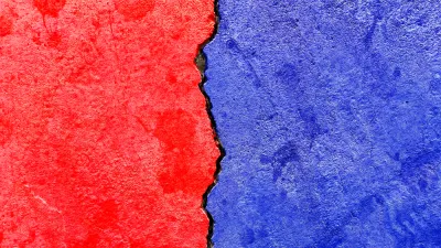 Concrete wall with crack running down the middle painted red on one side and blue on the other