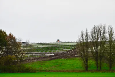 Solar panels on green inclined field on old landfill site in The Netherlands