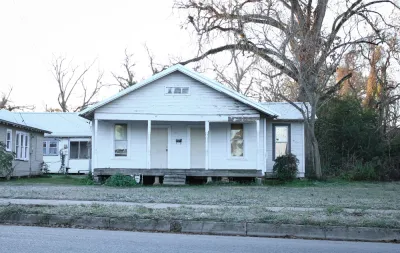 Dilapidated vacant wood slat house painted white in Louisiana