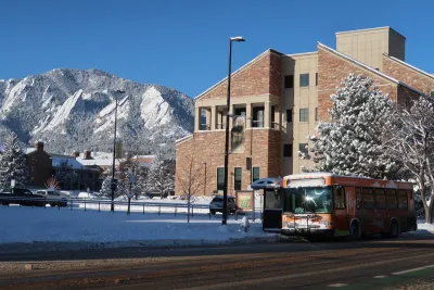 Bus stop in Boulder, Colorado with snowy tree and snowy mountains in background