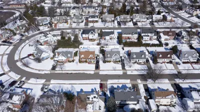 Aerial view of snowy single-family homes in suburban Long Island, New York