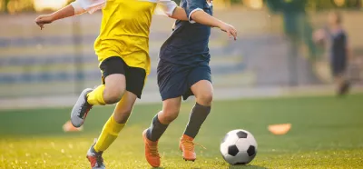 Two soccer players chasing a ball