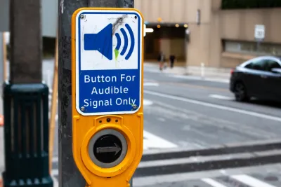 Close-up of crosswalk button for blind pedestrians labeled "button for audible signal only"
