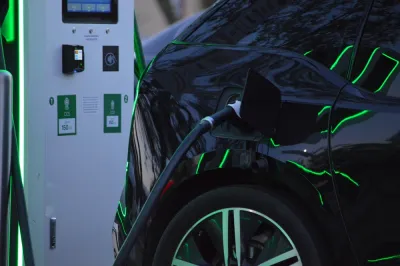 Close-up of black electric car charging at station