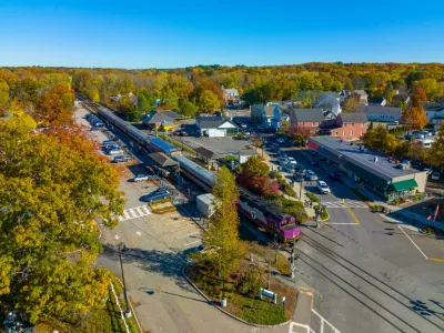 Aerial view of MBTA commuter rail station in Concord, Massachusetts among green trees