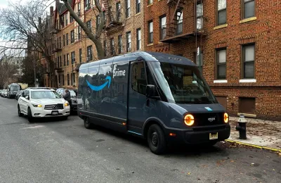 Rivian electric Amazon delivery van delivering packages curbside on New York City street