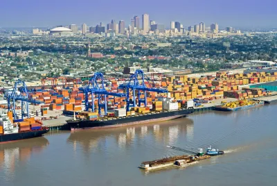 Aerial view of New Orleans port with cranes and barges and skyline in background