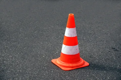 Orange traffic cone on black asphalt