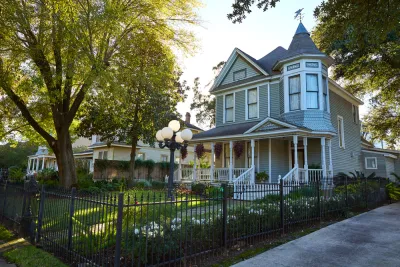 Light blue two-story Victorian home with corner turret in The Heights, Houston, Texas