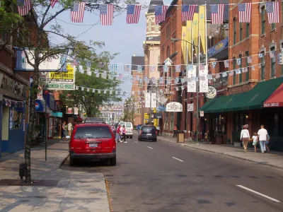 Two-lane street in Detroit's Greektown with American and Greek flags strung across the street