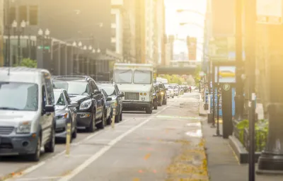 Bike lane and line of cars on street in Chicago with sun in background