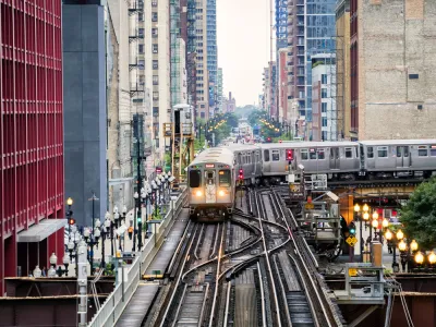 Chicago elevated train over busy city street surrounded by high-rise buildings