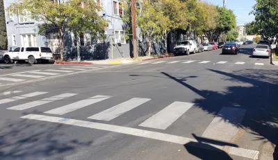 A white crosswalk painted by Crosswalk Collective LA in Los Angeles, California.