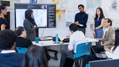 Image from one of Georgia Tech's capstone studios with students sitting and standing for a presentation