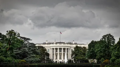 Front of White House with stormy sky above.