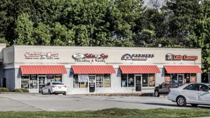 One-story strip mall with red awnings.