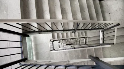 View looking down a multi-story apartment building staircase