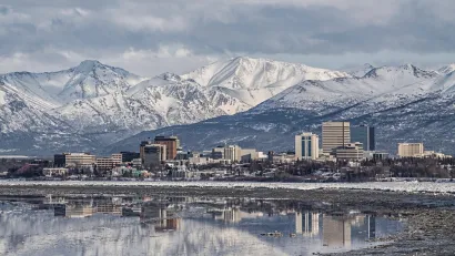 Downtown Anchorage with the snow covered Chugach Mountains in the background.