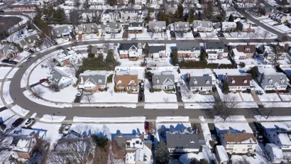 Aerial view of snowy single-family homes in suburban Long Island, New York
