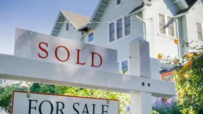 White house with For Sale and SOLD sign