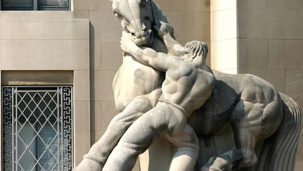 A stone statue of a shirtless muscular man wrestling with a powerfully built horse, his hands on the horse's neck, pulling downward.