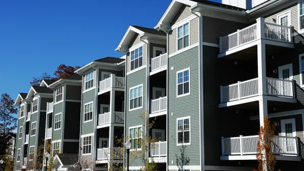 Four-story apartment building with gabled roofs.